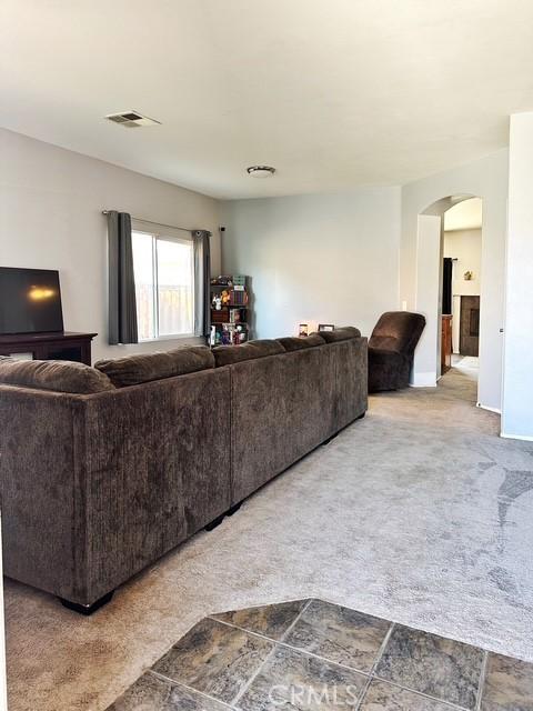 1380 Riverstone Ct, Hemet, CA 92545 - living room with arched walkways, carpet floors, visible vents, and baseboards