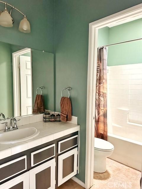 1380 Riverstone Ct, Hemet, CA 92545 - full bath with tile patterned flooring, toilet, vanity, and shower / tub combo with curtain