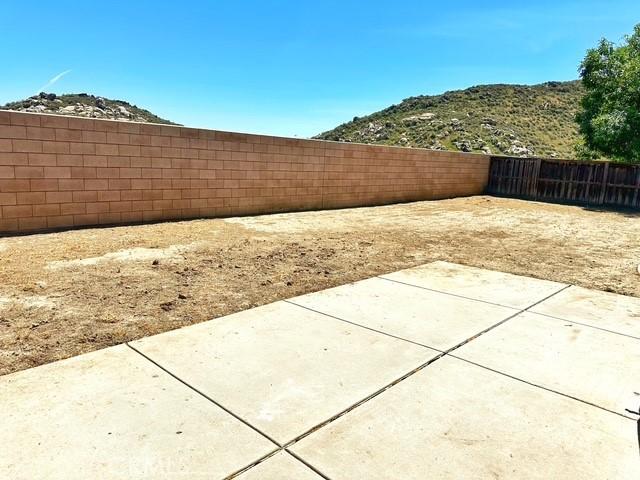 1380 Riverstone Ct, Hemet, CA 92545 - exterior space featuring a fenced backyard, a mountain view, and a patio