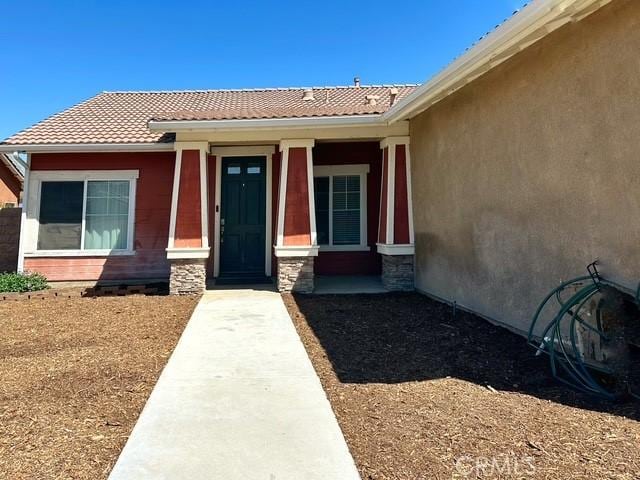 1380 Riverstone Ct, Hemet, CA 92545 - doorway to property with stucco siding, stone siding, and a tiled roof