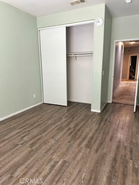 1380 Riverstone Ct, Hemet, CA 92545 - unfurnished bedroom featuring baseboards, dark wood-type flooring, visible vents, and a closet