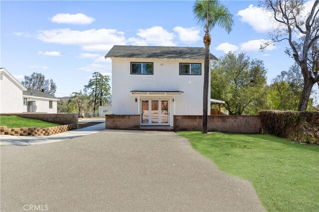 10321 Mcbroom St, Sunland, CA 91040 - view of front of house featuring french doors, a front lawn, stucco siding, and fence