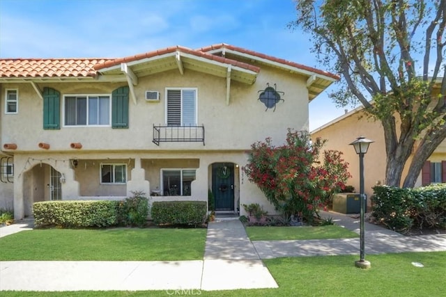 17274 Nisson Rd Unit A, Tustin, CA 92780 - mediterranean / spanish-style home featuring a tiled roof, a front yard, stucco siding, and a balcony