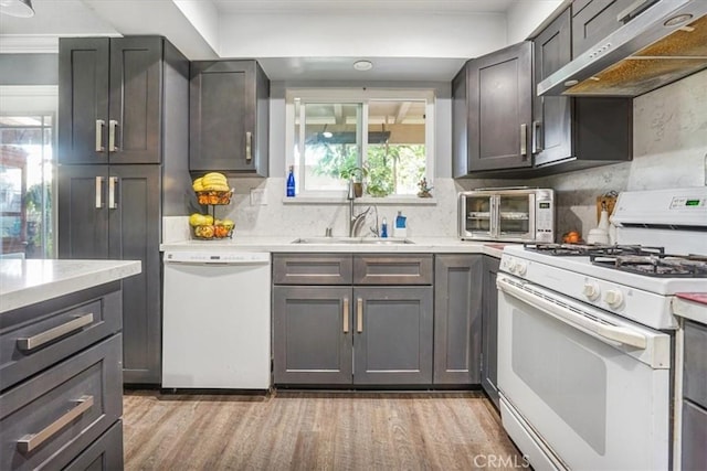 17274 Nisson Rd Unit A, Tustin, CA 92780 - kitchen with white appliances, under cabinet range hood, a sink, and light wood-style flooring