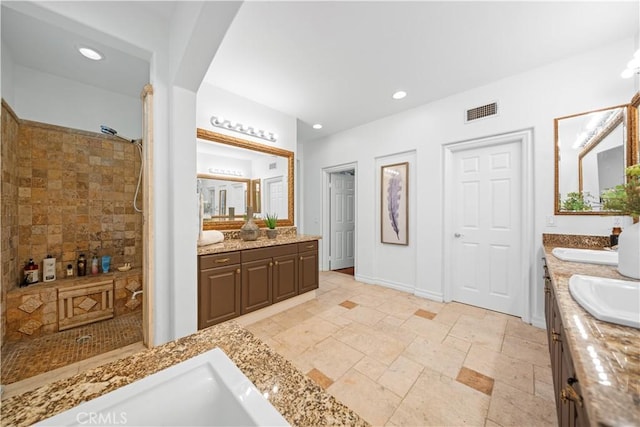 bathroom featuring recessed lighting, visible vents, vanity, and tiled shower