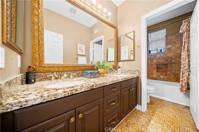 full bathroom with visible vents, a sink, double vanity, and toilet
