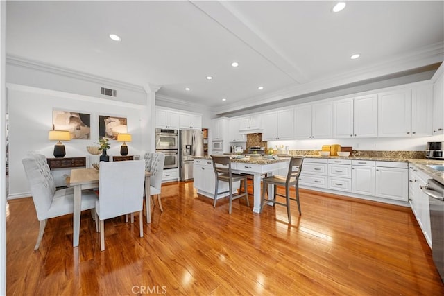 dining space with visible vents, recessed lighting, light wood-style floors, and ornamental molding