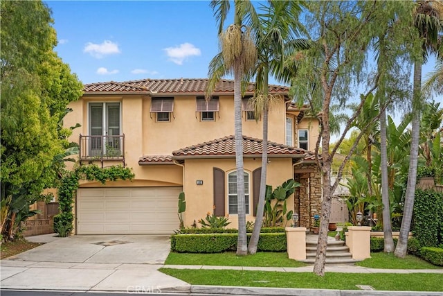 mediterranean / spanish-style home with a tile roof, concrete driveway, french doors, a garage, and stucco siding
