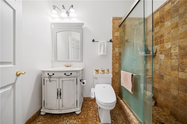 bathroom with a stall shower, vanity, and toilet