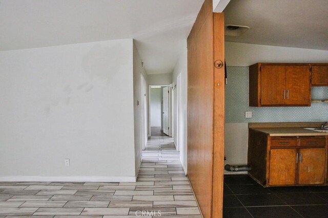 643 W Ramona Dr, Rialto, CA 92376 - kitchen featuring brown cabinets, backsplash, and wood finished floors