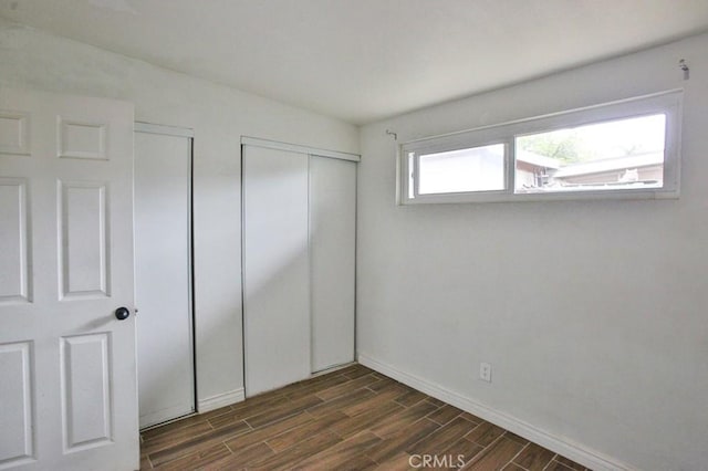 643 W Ramona Dr, Rialto, CA 92376 - unfurnished bedroom with dark wood-style floors and two closets