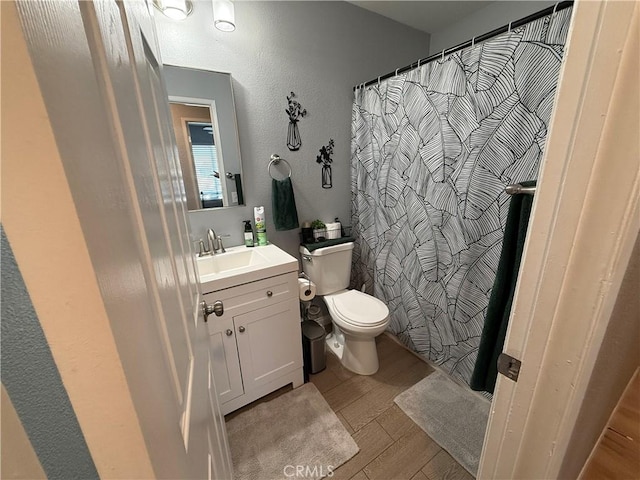 806 S Sandalwood Ave, Bloomington, CA 92316 - bathroom with wood finished floors, vanity, a textured wall, and a shower with shower curtain