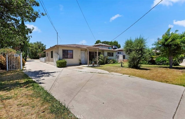 single story home with stucco siding, driveway, and a front yard