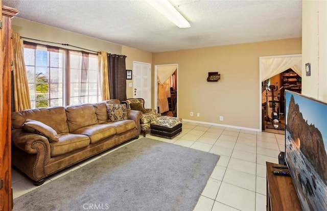 tiled living area featuring baseboards and a textured ceiling