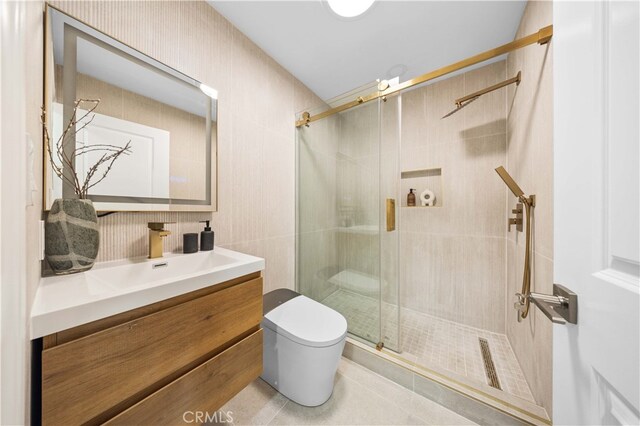 bathroom with a shower stall, tile patterned flooring, toilet, vanity, and tile walls