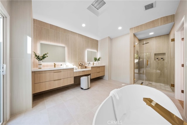 full bathroom featuring tile patterned floors, visible vents, a freestanding tub, a shower stall, and vanity