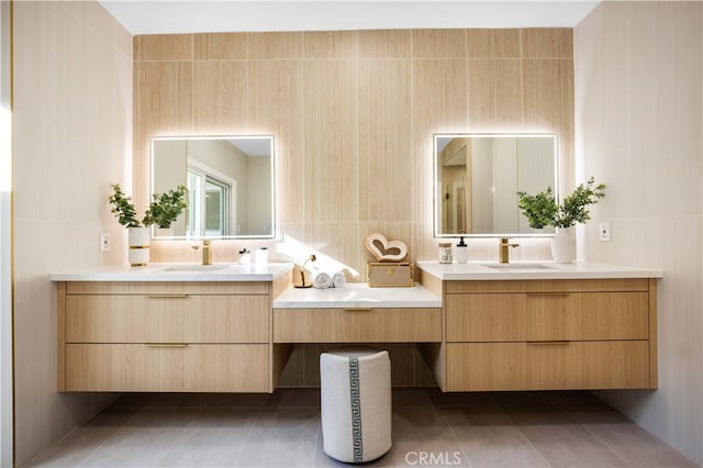 full bathroom with two vanities, a sink, and tile walls