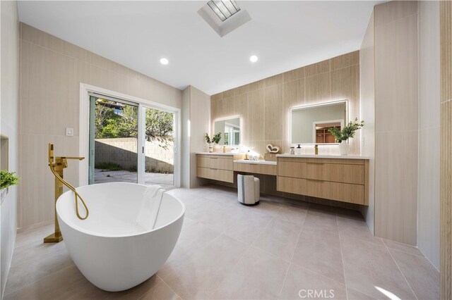 full bathroom featuring tile patterned floors, tile walls, recessed lighting, a freestanding tub, and vanity