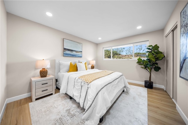 bedroom featuring recessed lighting, wood finished floors, a closet, and baseboards