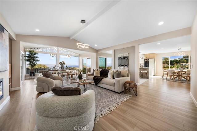 living room featuring recessed lighting, lofted ceiling with beams, an inviting chandelier, and light wood-style flooring