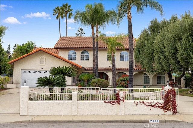 2177 W Silver Tree Rd, Claremont, CA 91711 - mediterranean / spanish home featuring stucco siding, a fenced front yard, concrete driveway, a tiled roof, and a garage