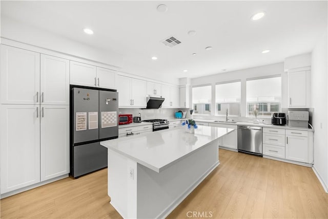 207 Colby Cir, Claremont, CA 91711 - kitchen with stainless steel appliances, white cabinets, light wood-type flooring, a kitchen island, and recessed lighting