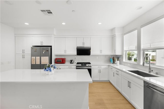 207 Colby Cir, Claremont, CA 91711 - kitchen featuring stainless steel appliances, light countertops, a sink, white cabinetry, and visible vents
