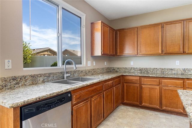 27674 Blue Topaz Dr, Menifee, CA 92585 - kitchen with light stone countertops, stainless steel dishwasher, a sink, and brown cabinets