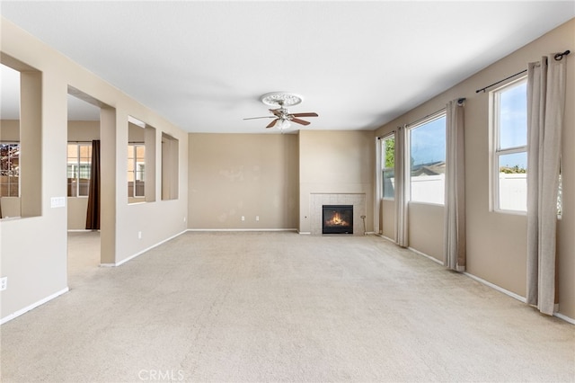 27674 Blue Topaz Dr, Menifee, CA 92585 - unfurnished living room featuring a tile fireplace, light colored carpet, and ceiling fan