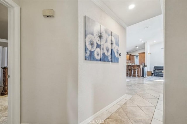 hallway with recessed lighting, vaulted ceiling, light tile patterned floors, crown molding, and baseboards
