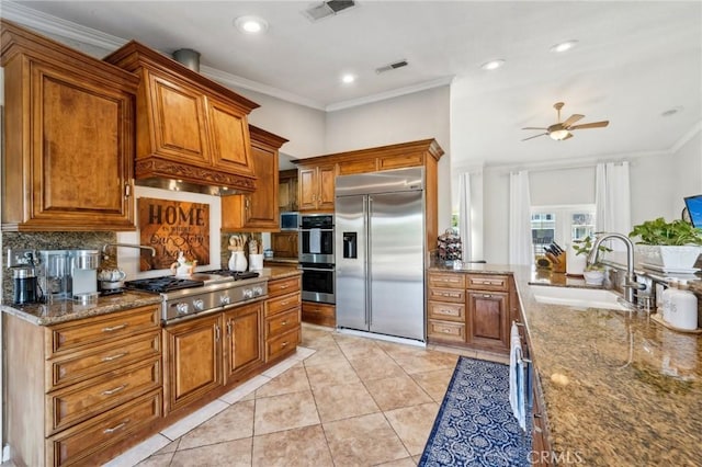 kitchen featuring stainless steel appliances, visible vents, backsplash, a ceiling fan, and brown cabinetry