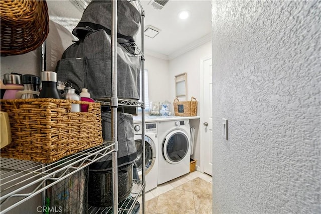 clothes washing area featuring tile patterned floors, washing machine and dryer, visible vents, laundry area, and ornamental molding