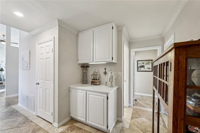 hallway with crown molding, light tile patterned floors, baseboards, visible vents, and recessed lighting