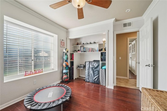 recreation room featuring wood finished floors, visible vents, crown molding, and ceiling fan