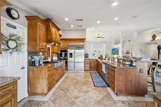 kitchen featuring crown molding, a sink, brown cabinets, ceiling fan, and stainless steel appliances