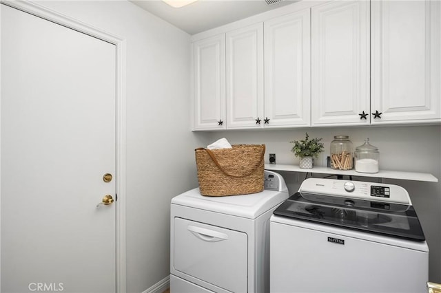 clothes washing area with washing machine and clothes dryer and cabinet space