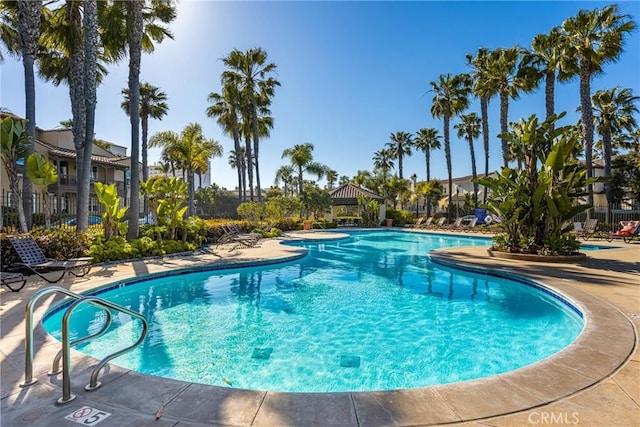 community pool featuring a patio area and fence