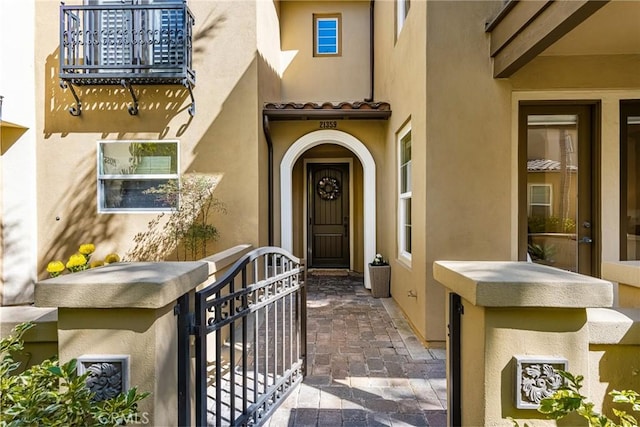 entrance to property featuring a tile roof and stucco siding