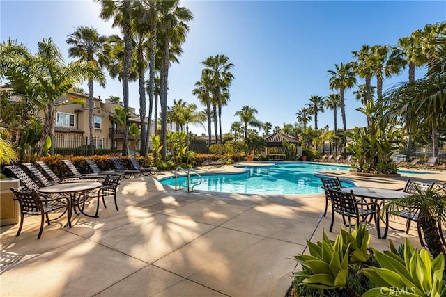 pool with a gazebo, fence, and a patio