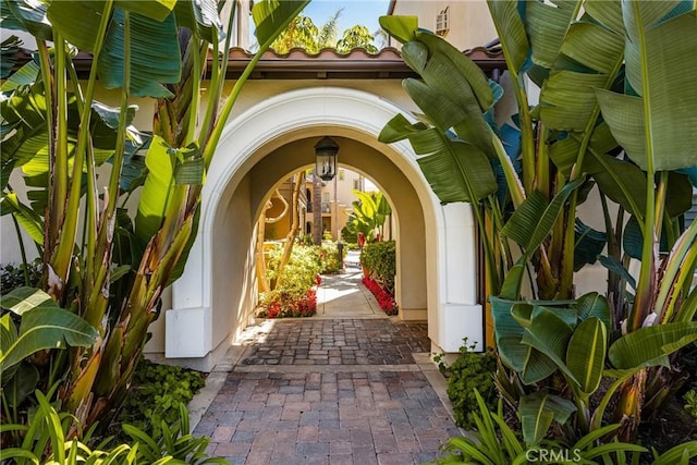 view of exterior entry featuring a tiled roof and stucco siding