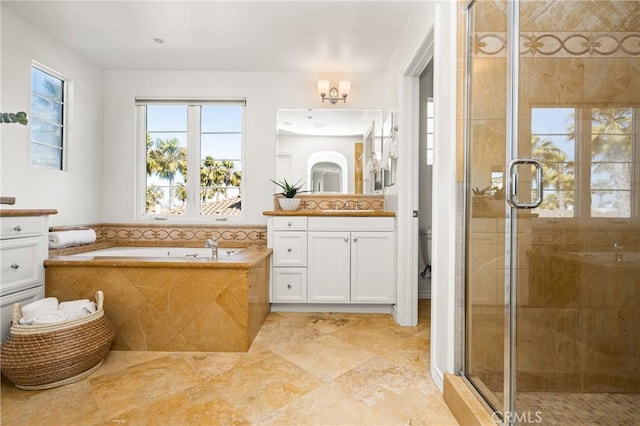 full bath with a bath, a shower stall, toilet, and vanity