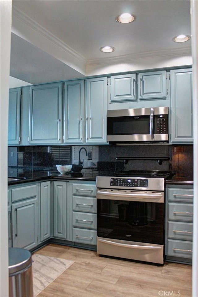 1007 S Catalina Ave Unit 212, Redondo Beach, CA 90277 - kitchen with appliances with stainless steel finishes, ornamental molding, tasteful backsplash, light wood finished floors, and recessed lighting