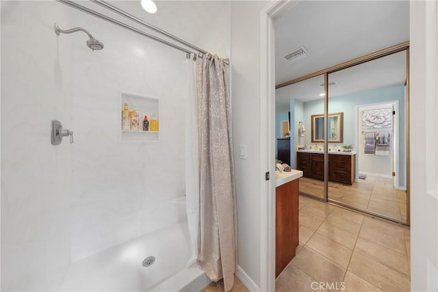bathroom with vanity, a stall shower, tile patterned floors, and visible vents