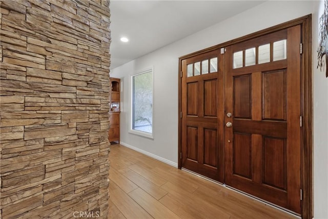 foyer featuring baseboards and light wood finished floors