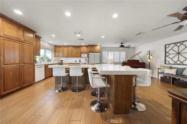 kitchen featuring light countertops, a ceiling fan, white appliances, and visible vents