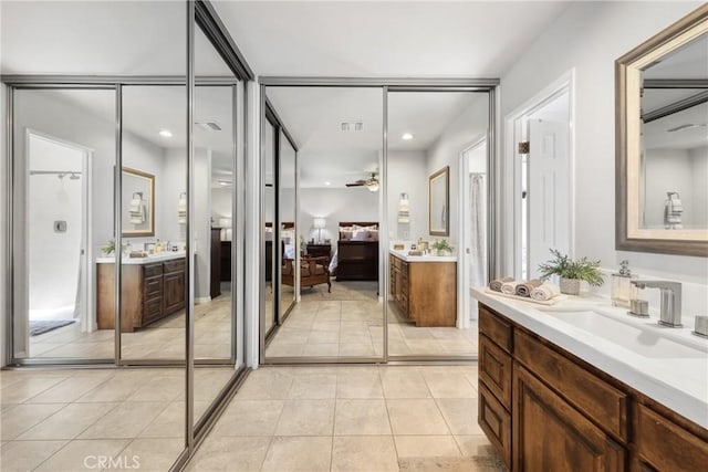 bathroom featuring a sink, a ceiling fan, tile patterned floors, and two vanities