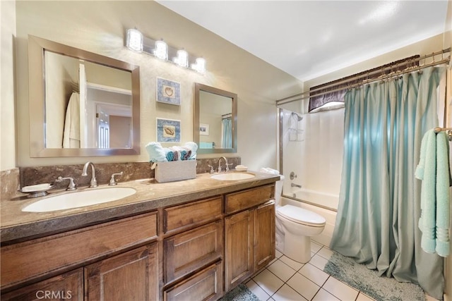 bathroom featuring double vanity, toilet, tile patterned floors, and a sink
