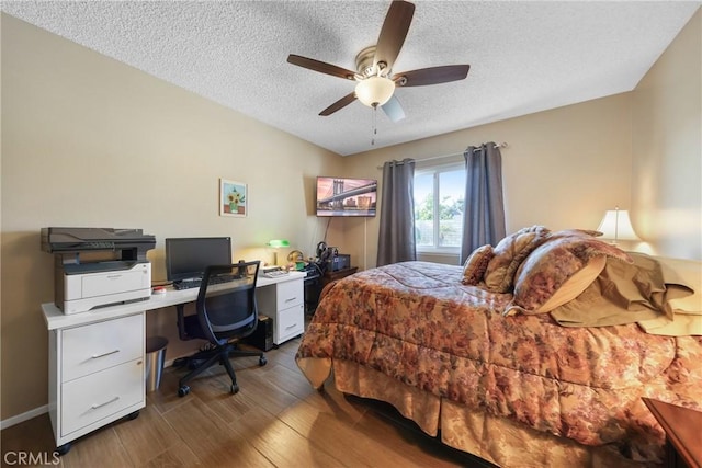 bedroom with a ceiling fan, a textured ceiling, and wood finished floors