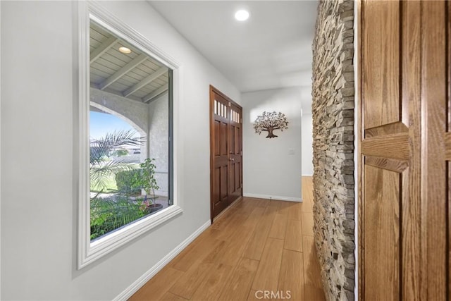 hall with baseboards, recessed lighting, and light wood-style flooring