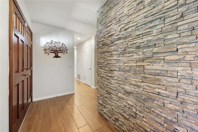 hall featuring baseboards, recessed lighting, and wood finished floors